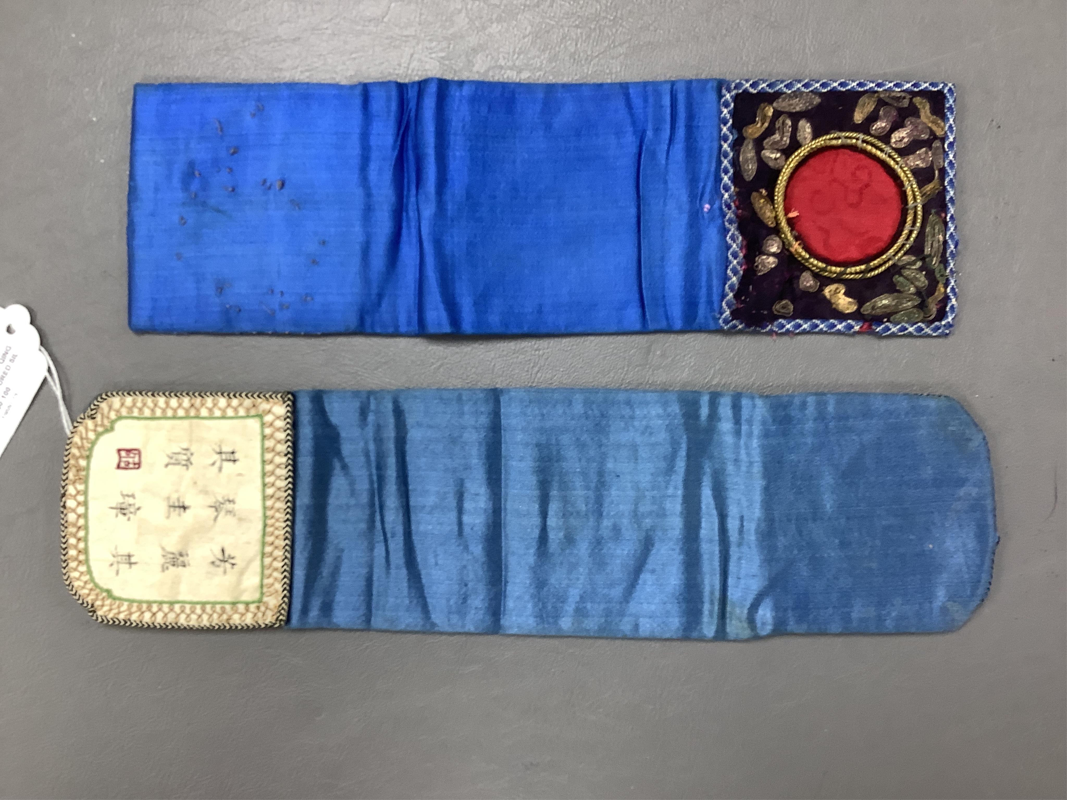 Two Chinese late Qing Dynesty coloured silk and gold thread embroidered belt purses, or ‘hebao’, for carrying coins, seals and fragrant herbs etc. One - 19cm long,in cream silk, with the embroidered words: “It’s music is